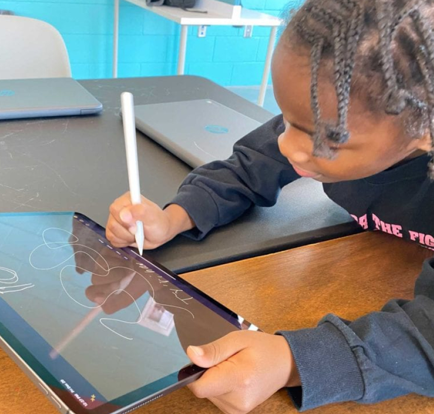 Child using a stylus on an iPad