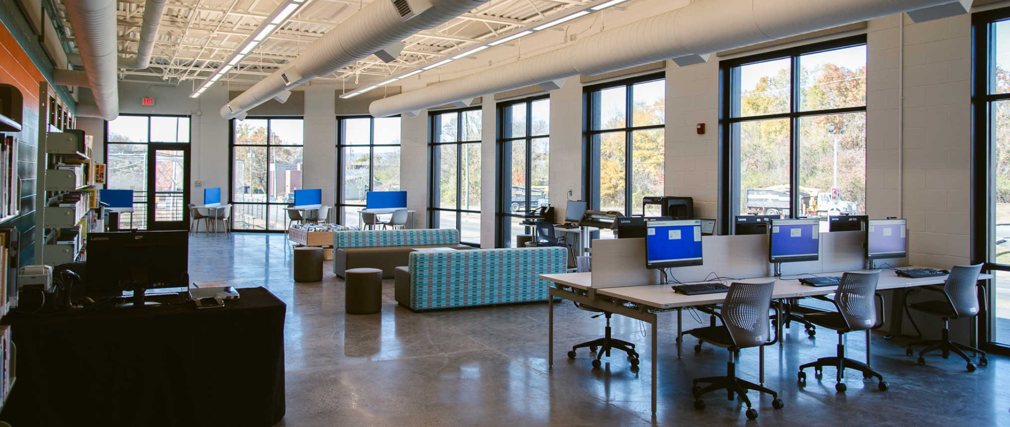 View of large room filled with tables and computers for patrons to use