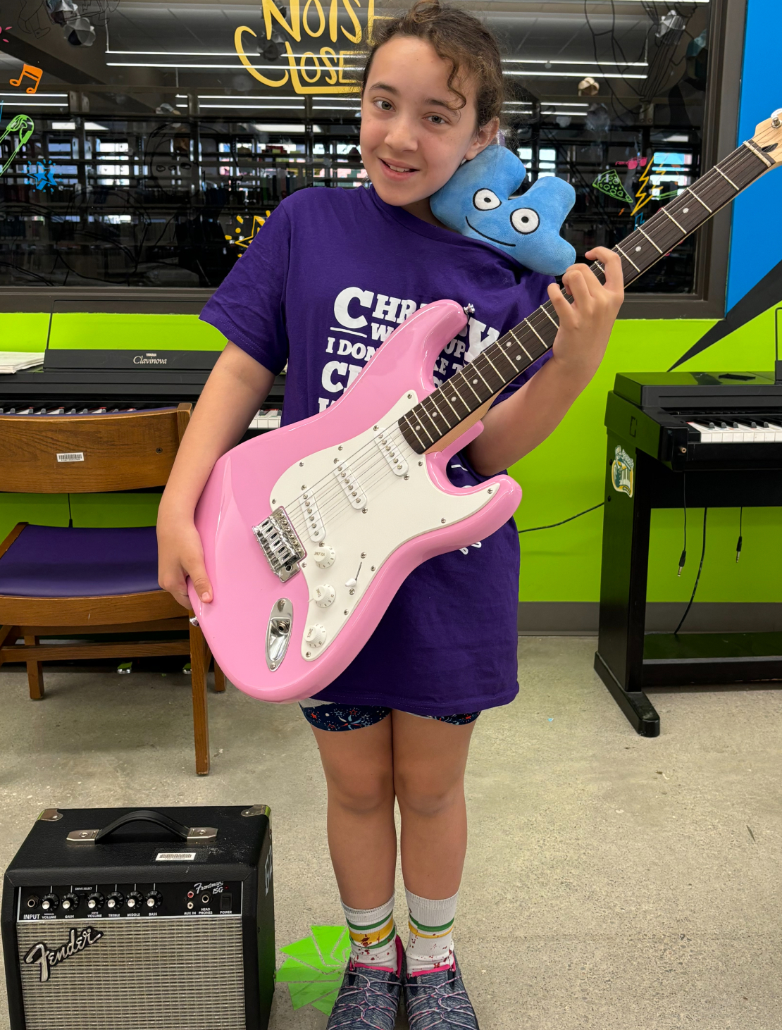 Young woman holding a pink electric guitar