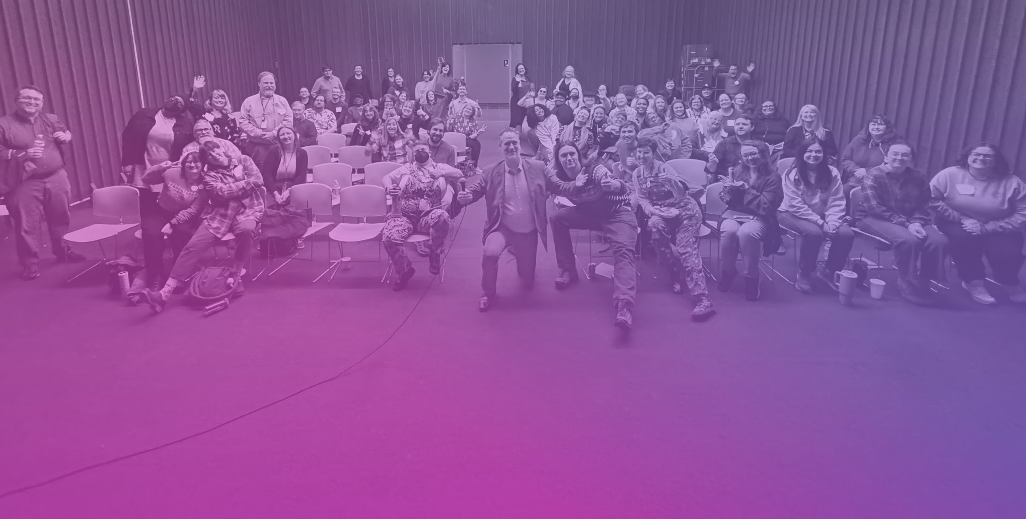 Library director posing for a photo with large group of seated people